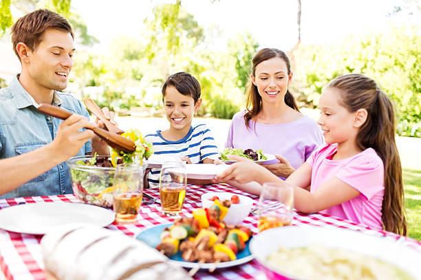 istock Man Serving Salad To Daughter At Lunch Table 507087591