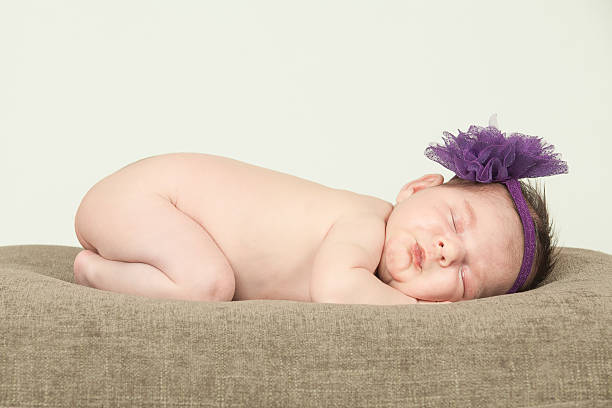 Naked sleeping newborn girl, with headband stock photo