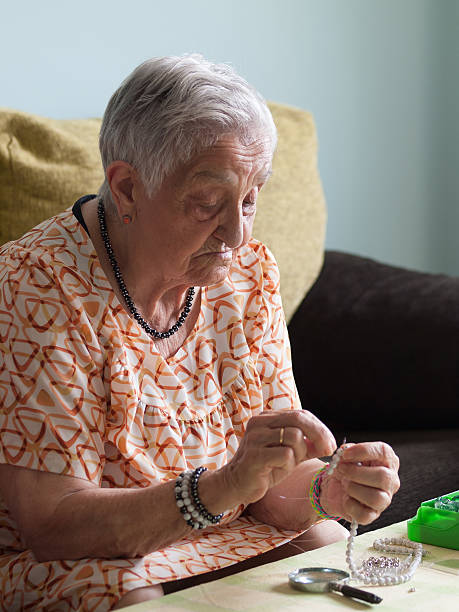 istock Elderly woman making necklaces 507092085
