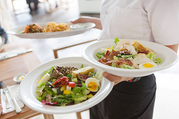 cameriera che serve cibo - salad caesar salad main course restaurant foto e immagini stock