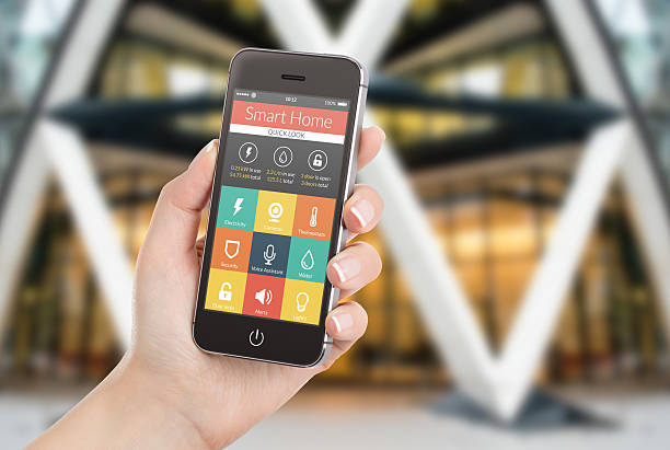 istock Female hand holding black phone with smart home application 507094841