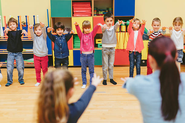 istock Group of children exercise with their teacher in kindergarten 507107196