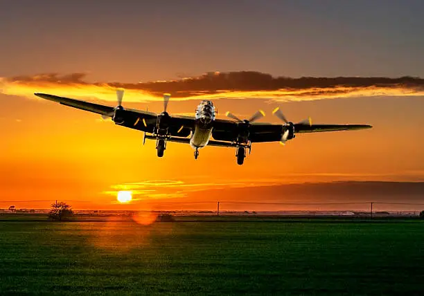 Bomber plane coming in to land at sunset over bomber county fields in Lincolnshire