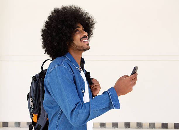 istock Smiling guy walking with cellphone and bag 507109160