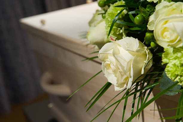 Coffin in morque A coffin with a flower arrangement in a morgue funeral parlor photos stock pictures, royalty-free photos & images