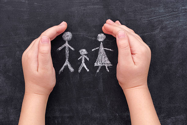 istock Child hands protecting family drawn on chalkboard 507111170