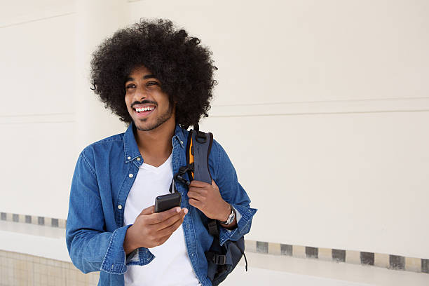 istock Fashionable young black man walking with cell phone 507111688