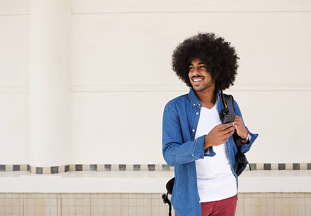 istock Cool guy smiling with bag and cellphone 507112162