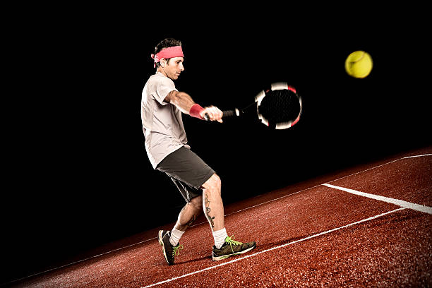 jugador de tenis de acción: revés - handsome man flash fotografías e imágenes de stock