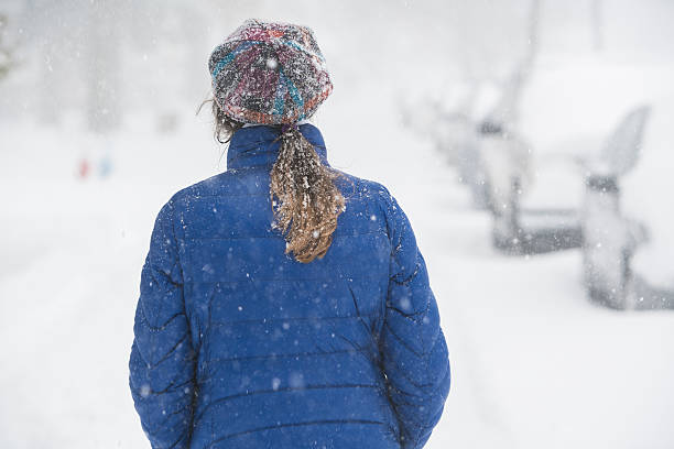 teenager-mädchen unter schneefall auf der straße - queens head stock-fotos und bilder