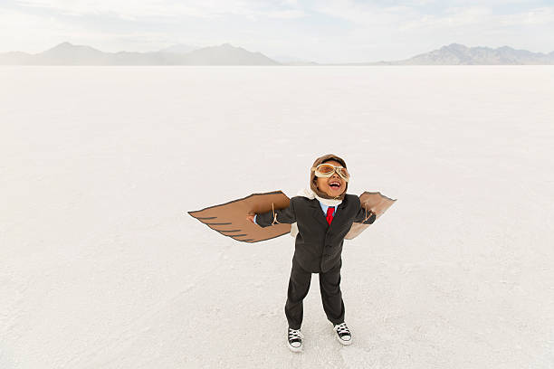 istock Young Boy Businessman Wearing Cardboard Wings 507115436