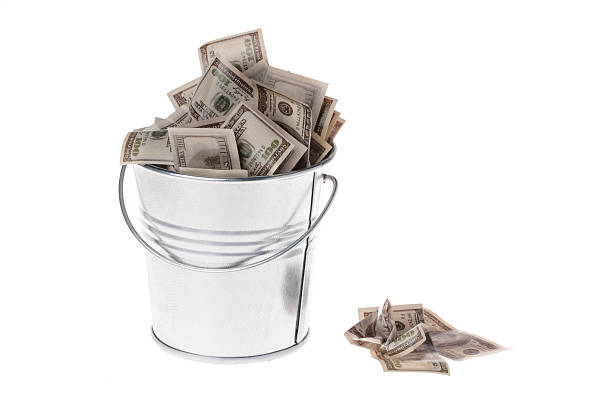 istock dollars in a metal bucket 507115778