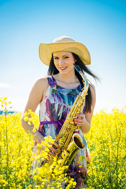 istock Woman with saxophone in rapeseed field 507116104