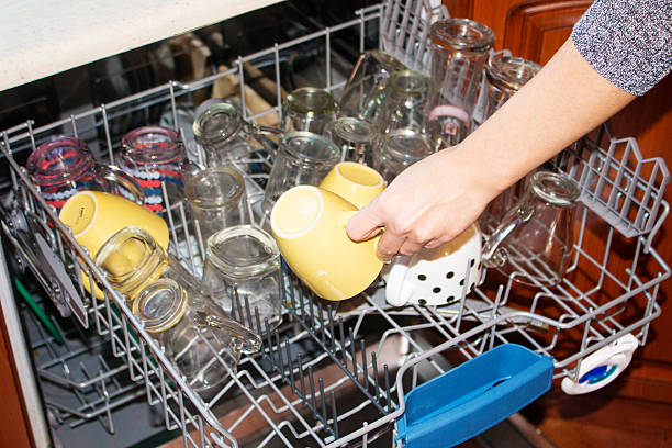 istock woman hand loading dirty dishes into dishwasher 507116634