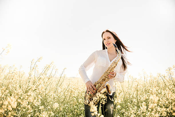 istock Woman with saxophone in rapeseed field 507116690
