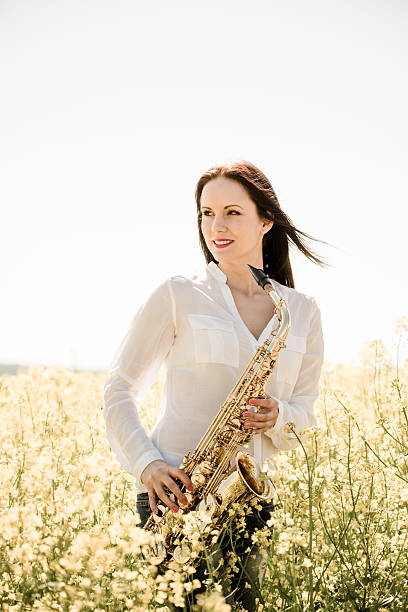 istock Woman with saxophone in rapeseed field 507117752