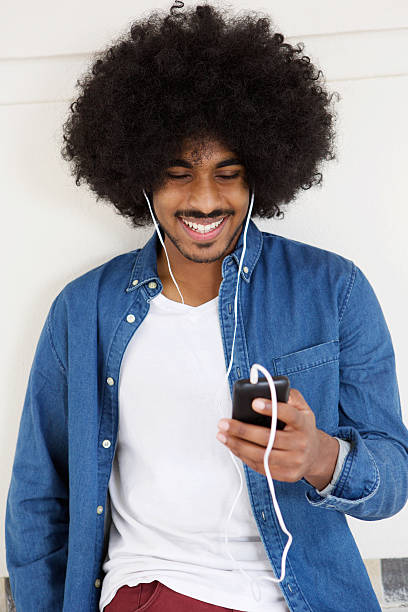 istock Cool guy smiling with mobile phone and earphones 507118740