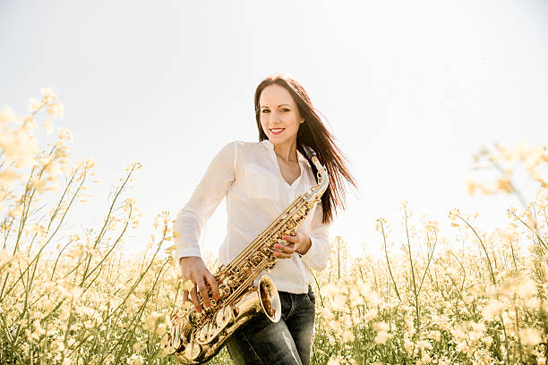 istock Woman with saxophone in rapeseed field 507118956