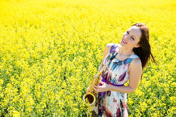 istock Woman with saxophone in rapeseed field 507120218