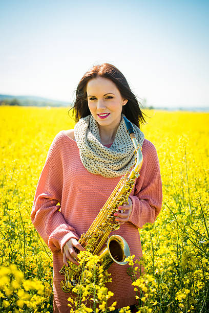 istock Woman with saxophone in rapeseed field 507121392