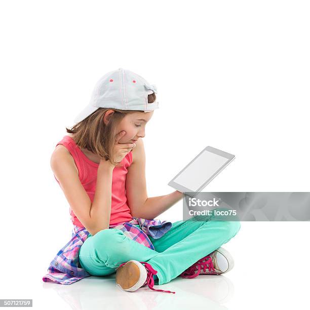 Girl Reading Algo Sobre Una Tableta Digital Foto de stock y más banco de imágenes de Niñas - Niñas, 10-11 años, Chica adolescente