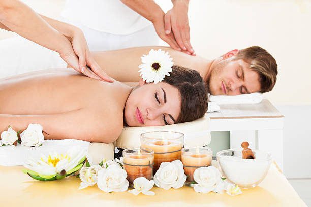 Portrait of smiling young couple receiving massage at spa