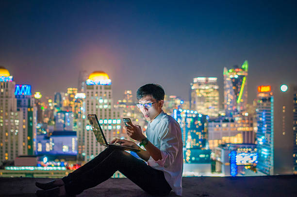 istock Businessman using a laptop on the rooftop of a skyscraper 507122320