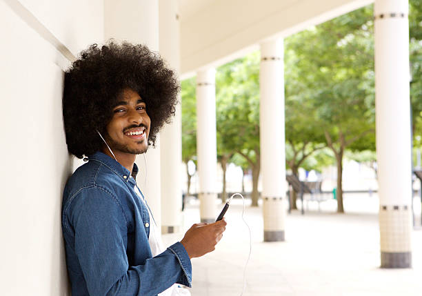 istock Cool black guy standing outside with mobile phone 507122666