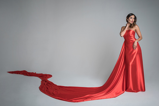 Beautiful elegant woman in a long red evening dress - fashion concepts