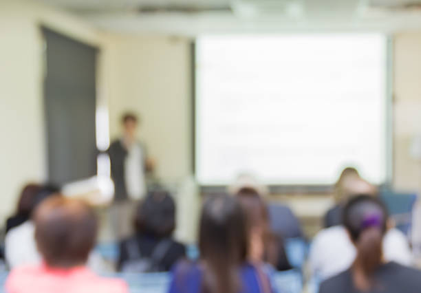 istock Blur audience sitting in conference room and lecturer  with screen 507123010