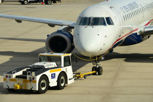 Philadelphia, Pennsylvania, USA - May 25, 2013: a tug pushes back and US Airways aircraft from the gate at Philadelphia International Airport