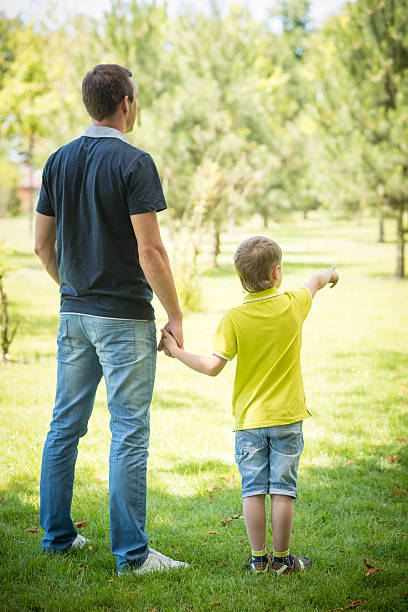 istock Cheerful father and his son against park 507125419