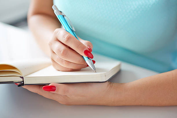 istock Young woman writes to black diary 507126957
