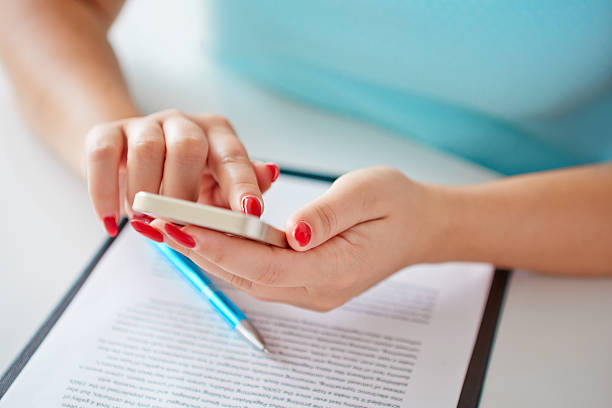 istock Young woman working with a mobile phone above the contract 507126995