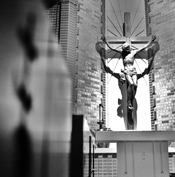 Jesus crucified hanging on the holy wooden cross of salvation This lovely image of Jesus crucified upon the wooden cross was hanging within Christ the King Church, in Tulsa, Oklahoma. It shows the Passion journey of Christ, and also the redemptive suffering.  agnus dei stock pictures, royalty-free photos & images