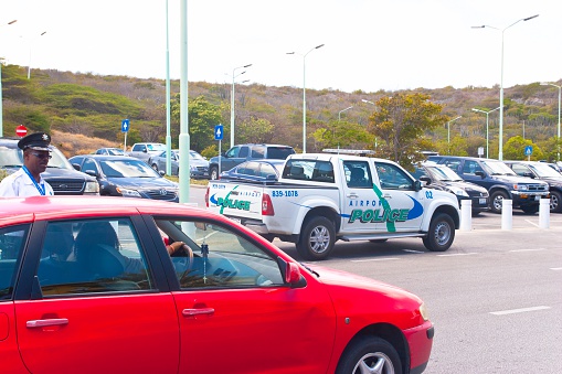 Willemstadt, Cracao - March 31, 2014: Police officer from the airport police checking a driver at the international airport of Curacao.