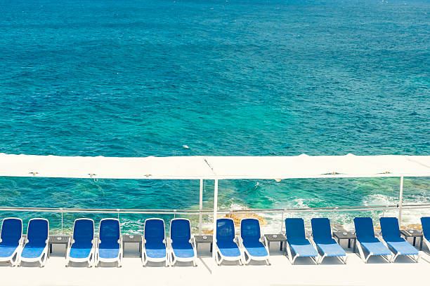 istock Blue deck chairs in line at the sea 507153062