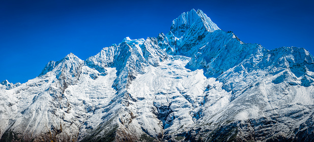 The snow capped peaks, dramatic rocky pinnacles and high altitude Himalaya ridges of Thamserku (6608m) towering over the picturesque mountain scenery of the Khumbu region deep in the Everest National Park, Nepal. ProPhoto RGB profile for maximum color fidelity and gamut.