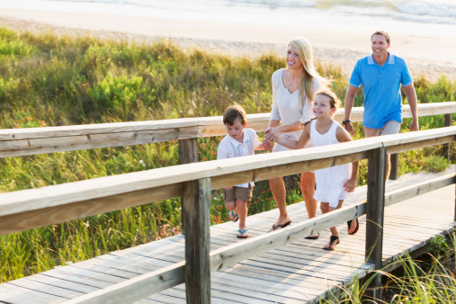 Family running on beach boardwalk.  Main focus on mother.