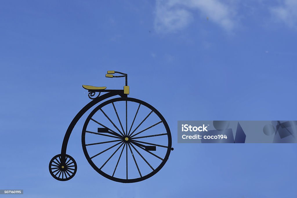 High Wheeler A high wheeler symbol with blue sky background Penny Farthing Bicycle Stock Photo