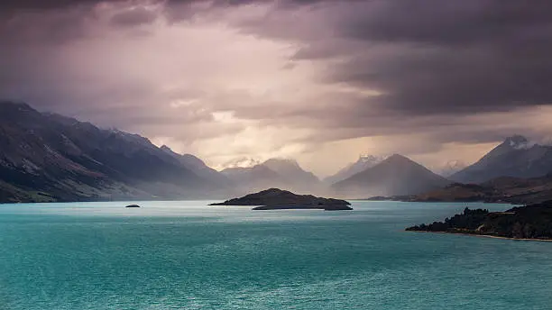 A stormy sunset over Mount Aspiring National Park with Lake Wakatipu and Glenorchy in the foreground. South Island/New Zealand