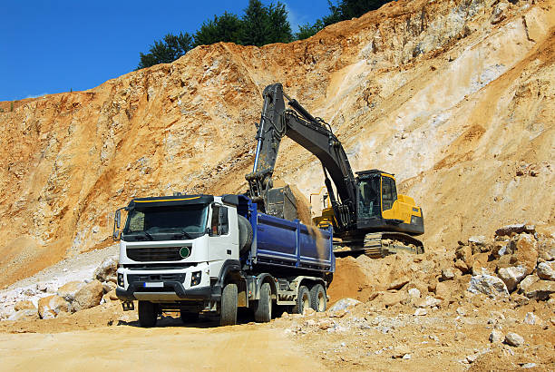 istock Yellow excavator and big truck 507168072