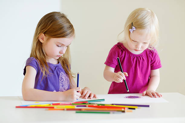 istock Two little sisters drawing with colorful pencils 507171376
