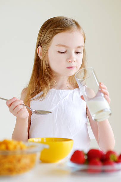istock Adorable little girl eating cereal in a kitchen 507171988
