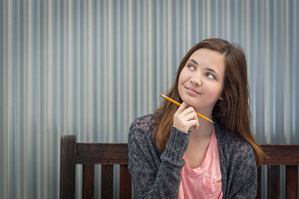 istock Young Daydreaming Female Student With Pencil Looking to the Side 507172900