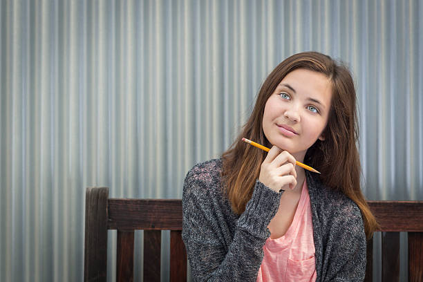 istock Young Daydreaming Female Student With Pencil Looking to the Side 507172940