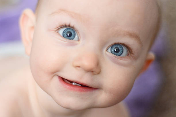 lächelnd baby mädchen im bad - blaue augen stock-fotos und bilder