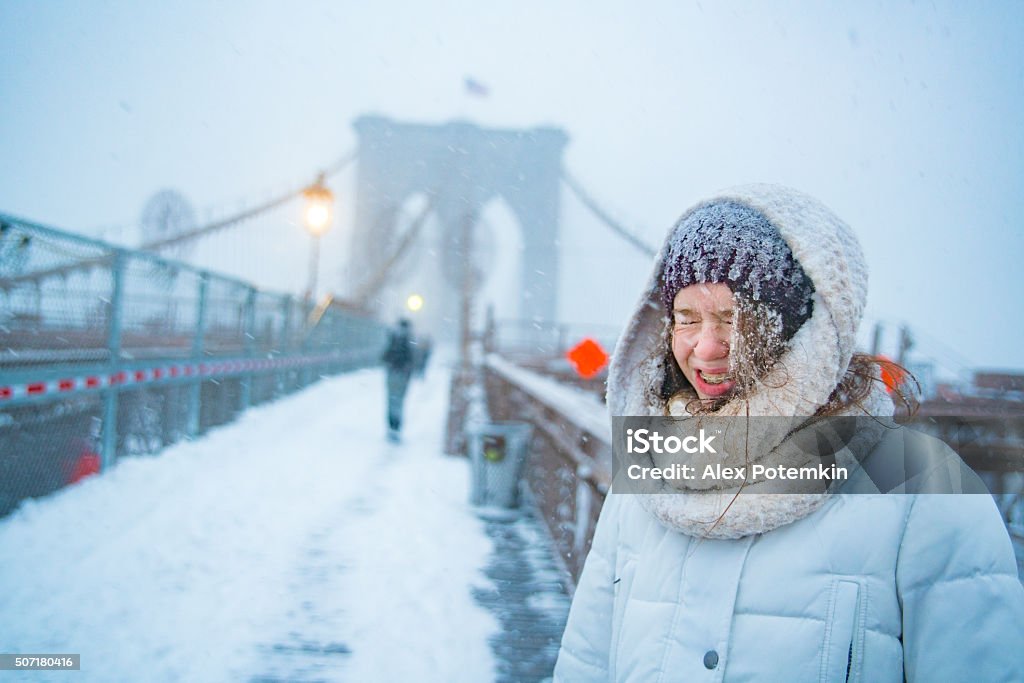 Teenager girl at the Brooklyn Bridge under snowfall Teenager girl under snowfall at the Brooklyn Bridge, Manhattan-Brooklyn, New York City, NY, during the snowstorm Jonas 14-15 Years Stock Photo