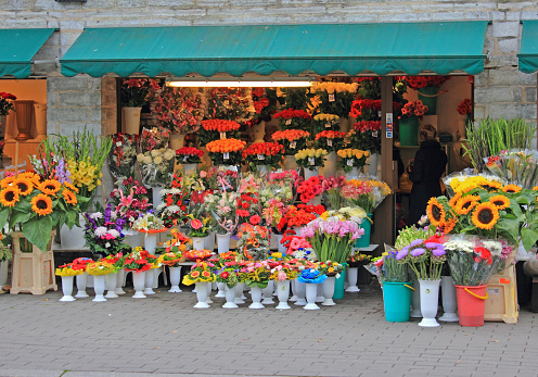 Tallinn, Estonia - September 12, 2012: Flower shop with colorful flowers on display on sidewalk, urban setting.