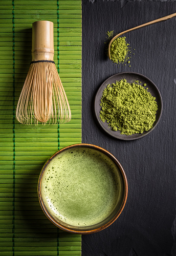 Still life with Japanese matcha accessories and green tea in bowl